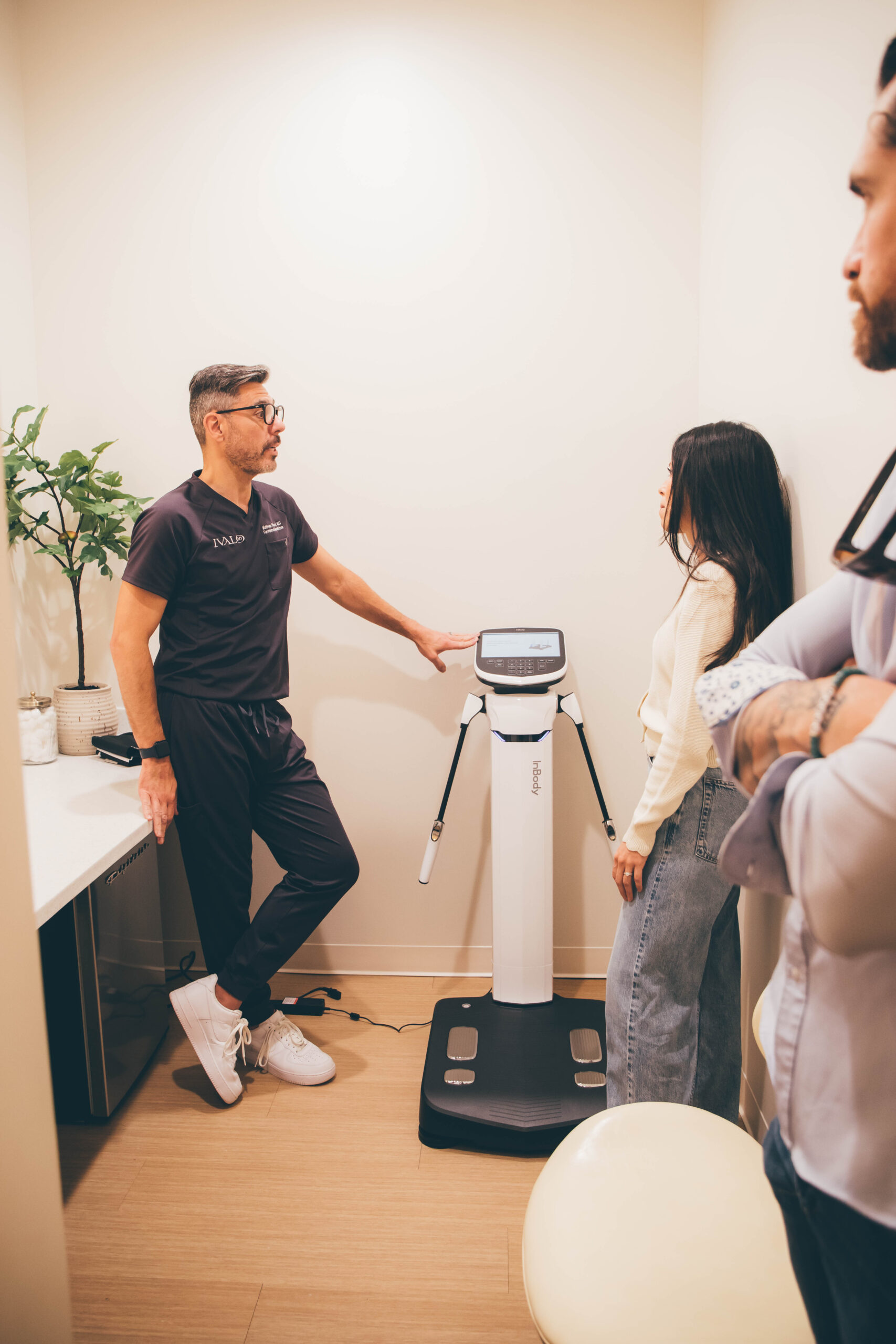 Dr. Sokol assisting a patient with a body composition analysis machine.