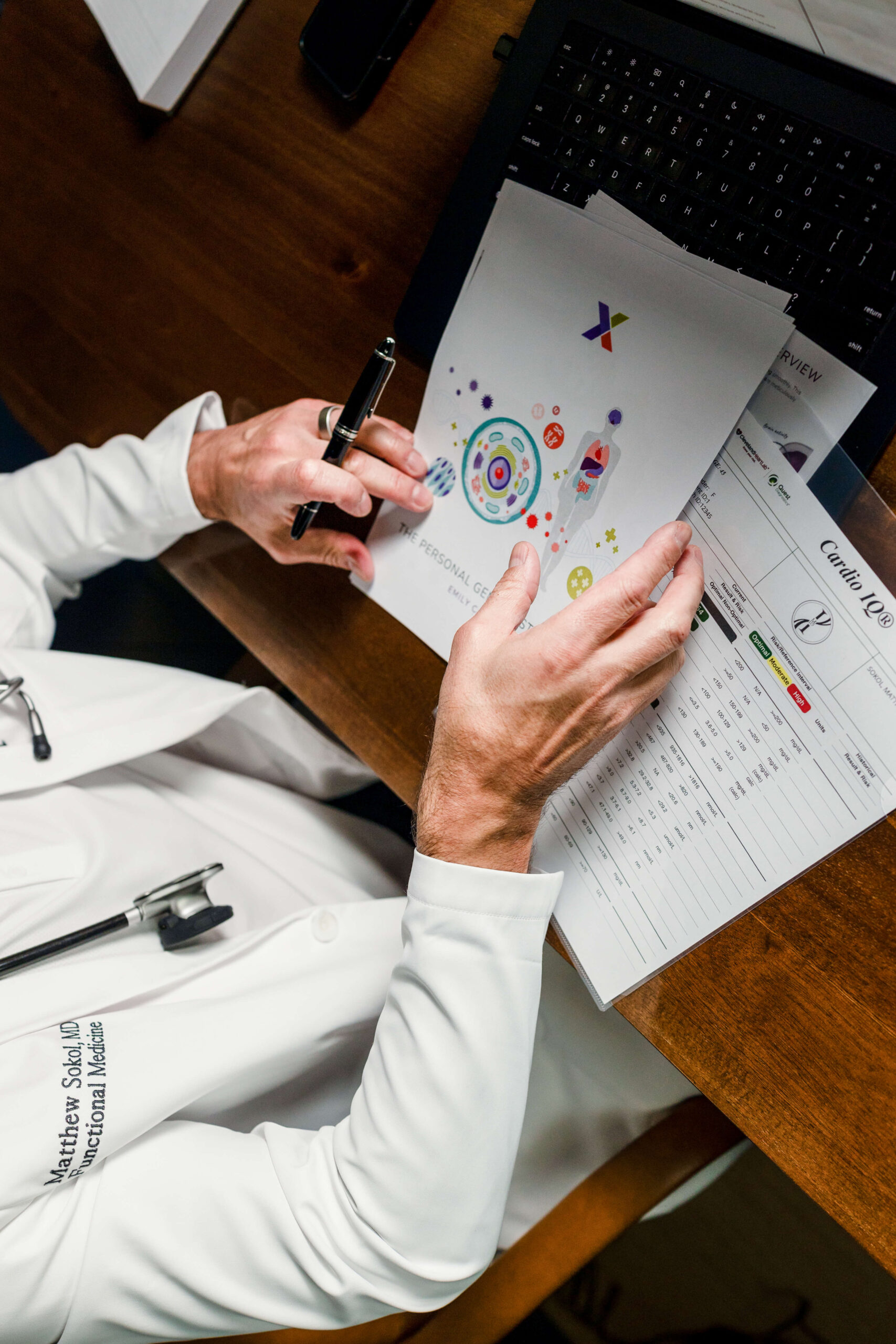 Overhead view of Dr. Sokol's hands annotating colorful lab result charts