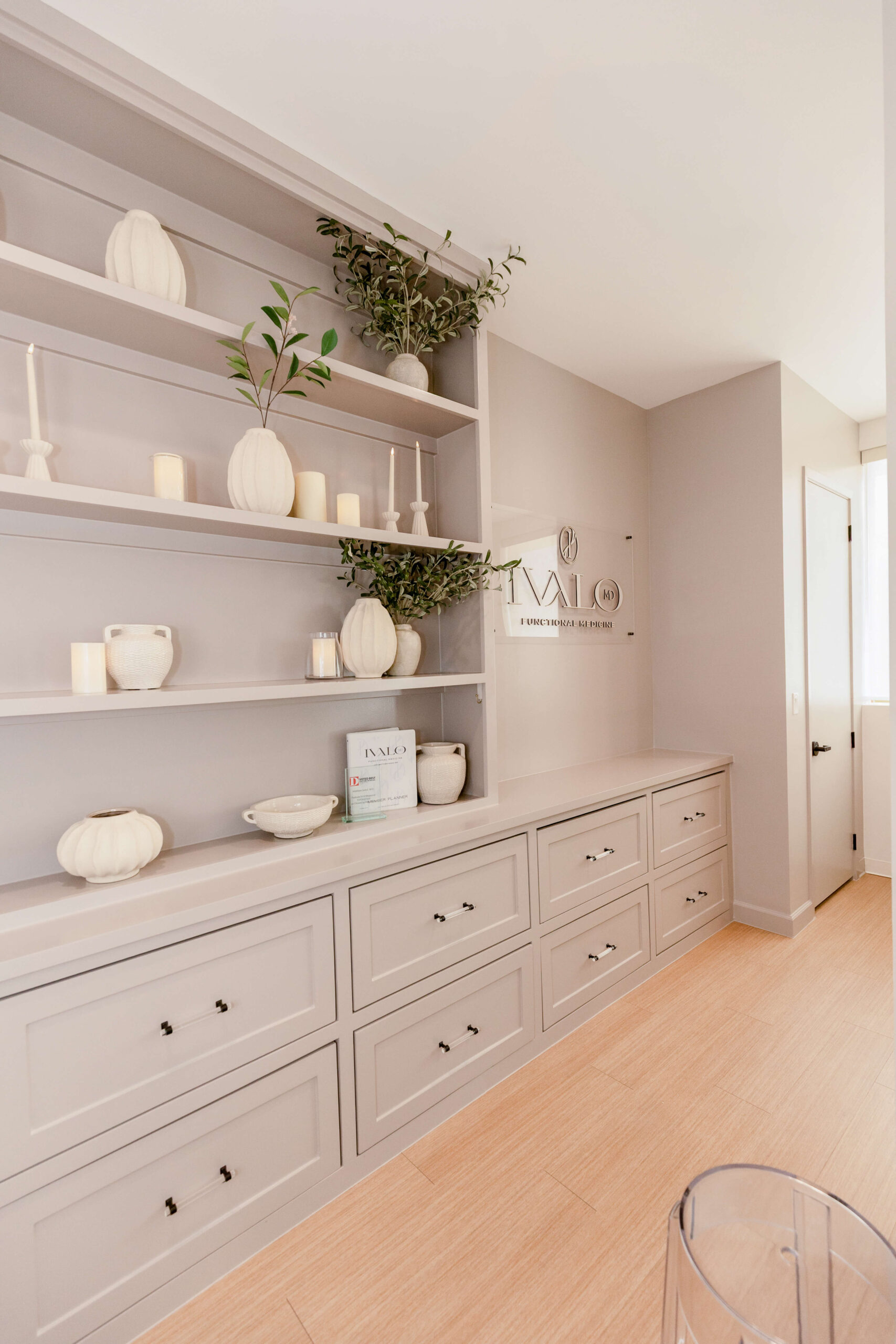 Bright clinic workspace with a white desk, chairs, and greenery at Ivalo MD